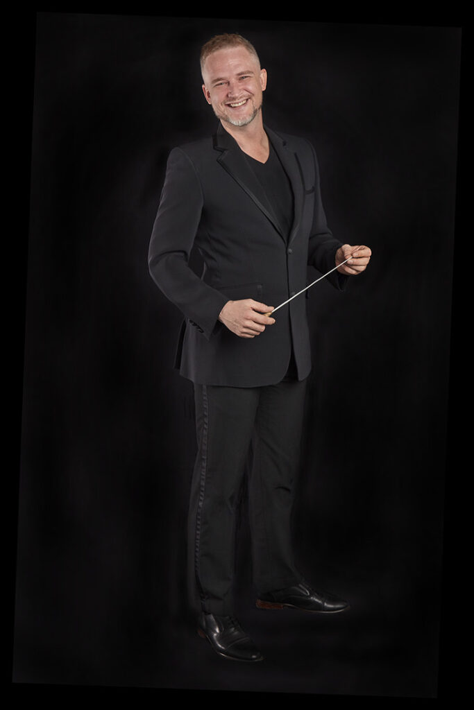 Conductor James Welsch in black tux holding a conducting baton